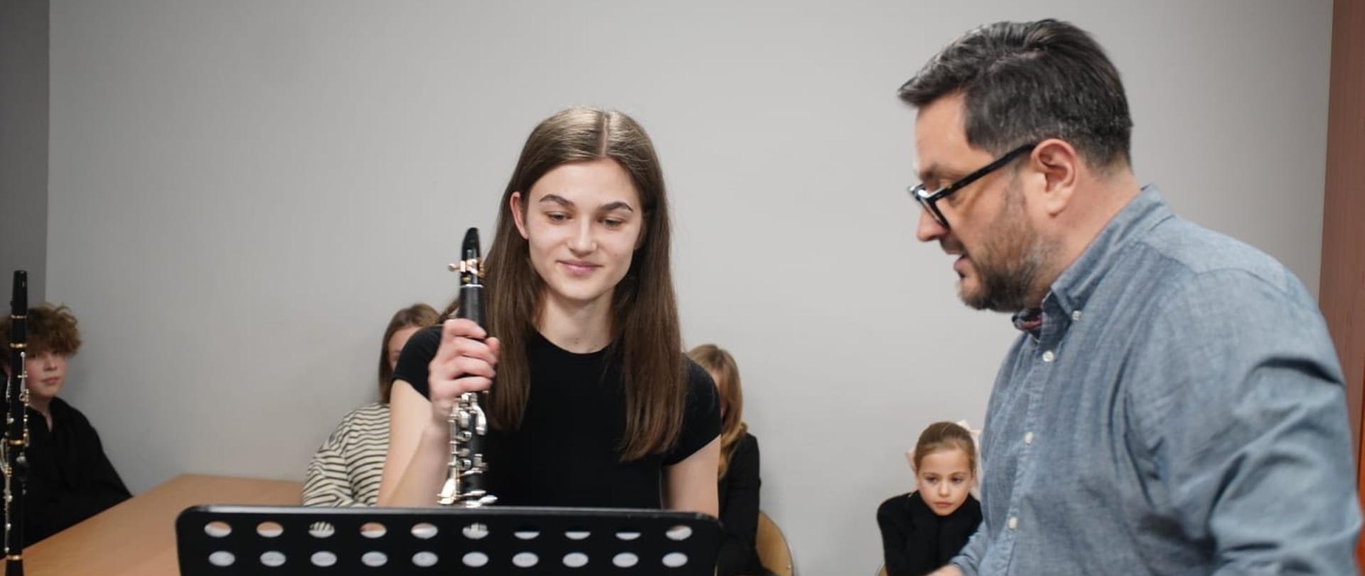 Uczennica podczas warsztatów klarnetowych, z prawej strony profesor.