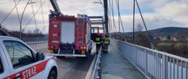 Samochody oraz strażacy na moście