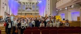 Wszyscy uczniowie biorący udział w wycieczce i nauczycielki stoją przed sceną Filharmonii.