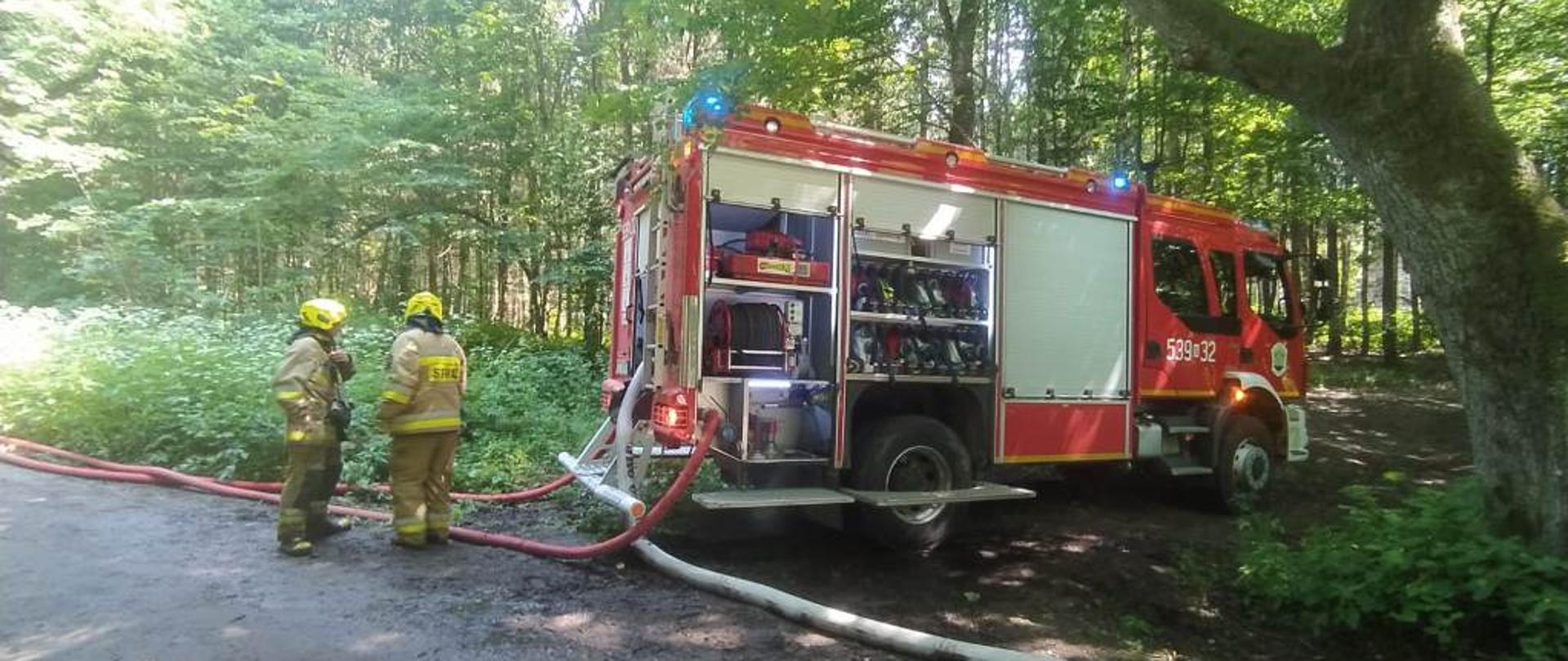 Z kolejnego samochodu pożarniczego rozwinięte są wężowe linie gaśnicze. 