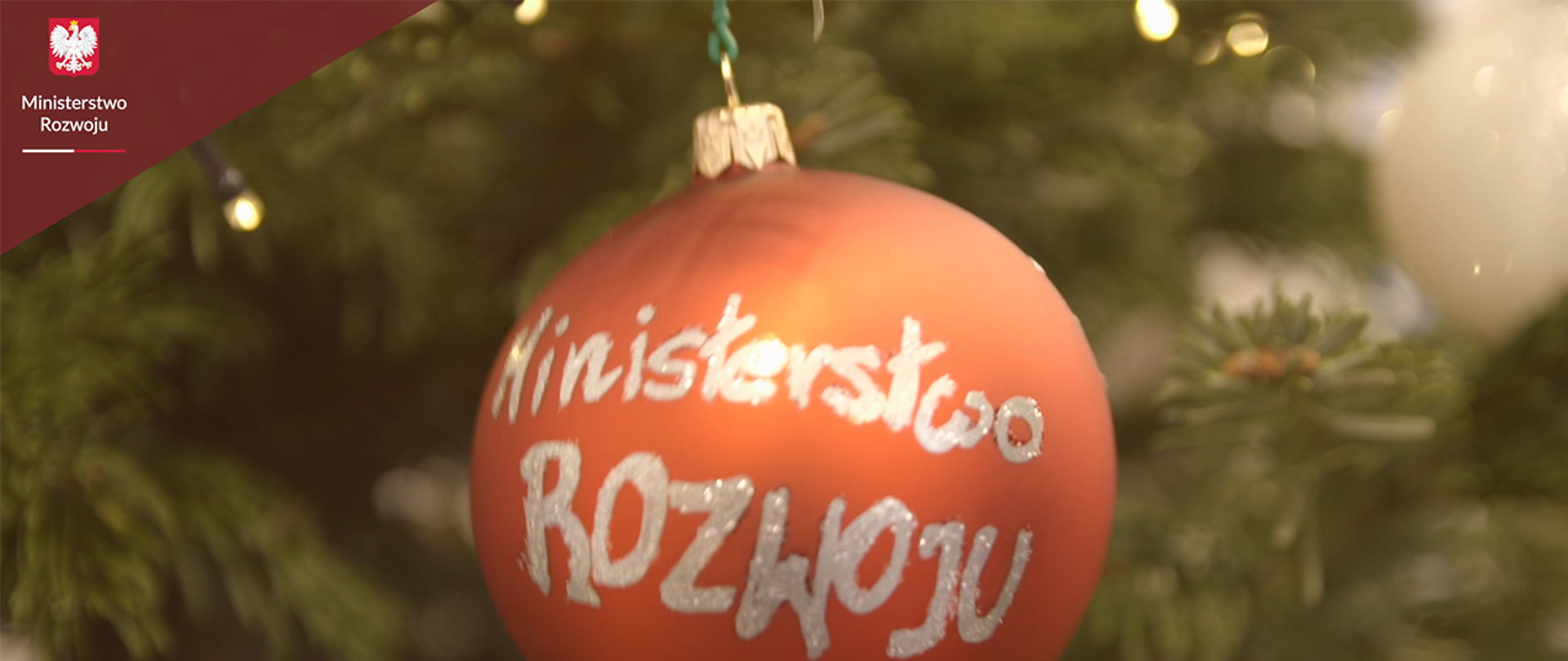 Na pierwszym planie bombka z napisem Ministerstwo Rozwoju, w tle gałązki choinki.