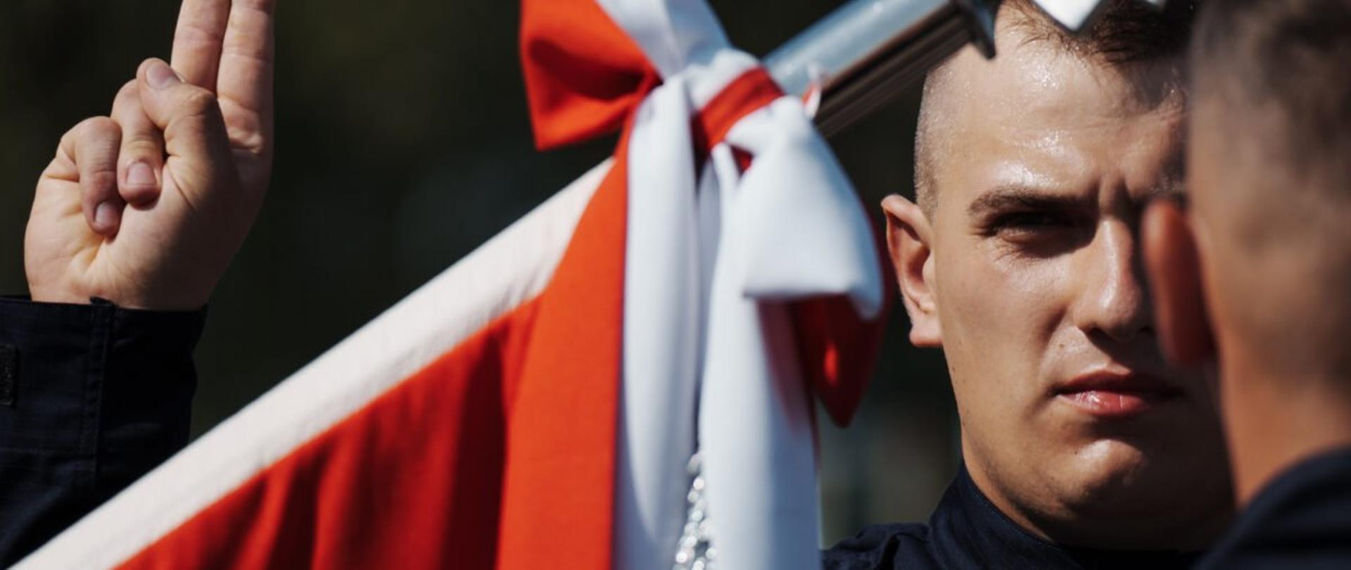 Policjant składający przysięgę przy sztandarze