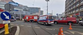Na skrzyżowaniu widać samochody straży pożarnej oraz karetki pogotowia ratunkowego.