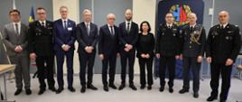 Uczestnicy delegacji oraz funkcjonariusze Państwowej Straży Pożarnej i przedstawiciele instytucji partnerskich pozują do wspólnego zdjęcia w Akademii Pożarniczej.