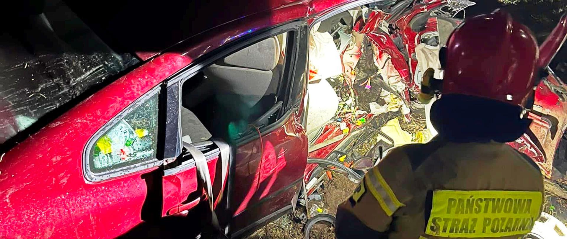 Rozbity samochód oraz strażak PSP obok