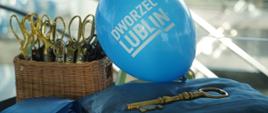 Otwarcie nowego dworca w Lublinie, niebieski balon z napisem dworzec Lublin, klucz i nożyczki w koszyku