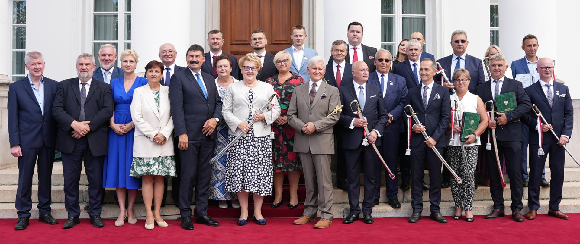 Sekretarz stanu R. Bartosik stojący wraz laureatami