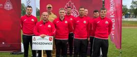 Drużyna strażaków w strojach sportowych pozuje do zdjęcia