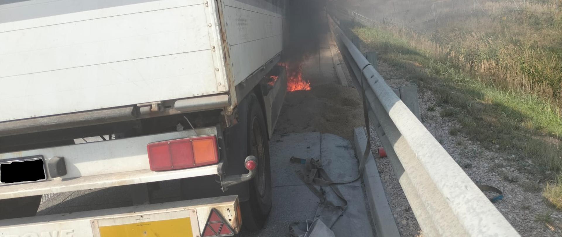 Widok z tyłu na naczepę spod której wydobywa się ogień