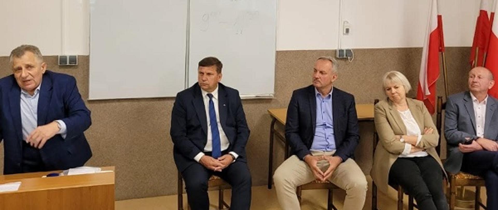 Przemówienie: Zdjęcie przestawia Świętokrzyskiego Wojewódzkiego Inspektora Ochrony Roślin i Nasiennictwa przemawiającego z mównicy do zebranych. Po prawej stronie Wicewojewoda Pan Michał Skotnicki oraz troje słuchaczy oraz flagi polskie.