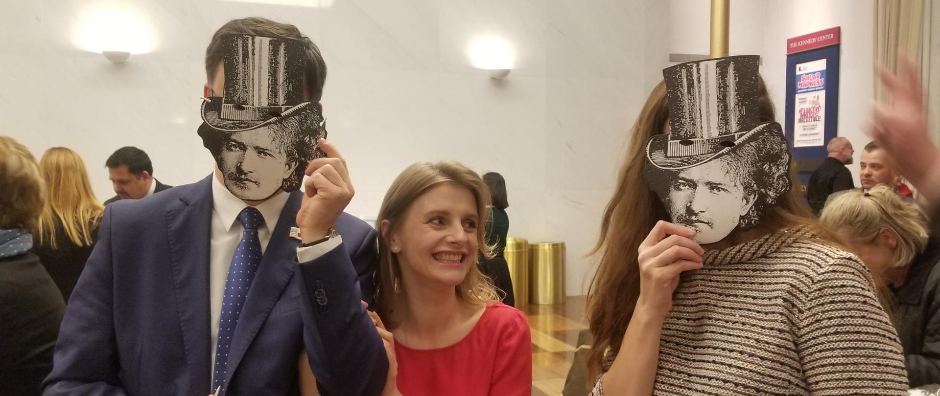 Three people attending the premiere of "3 Paderewskis," with two of them wearing masks featuring the likeness of Paderewski 