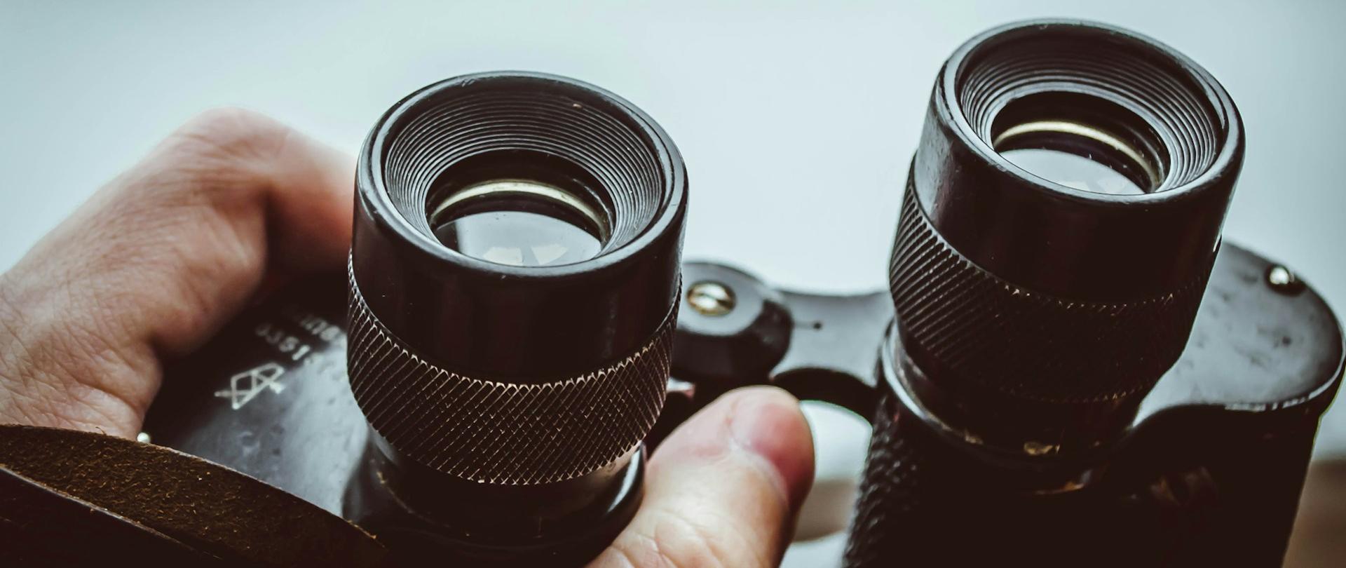 dłonie trzymające lornetkę