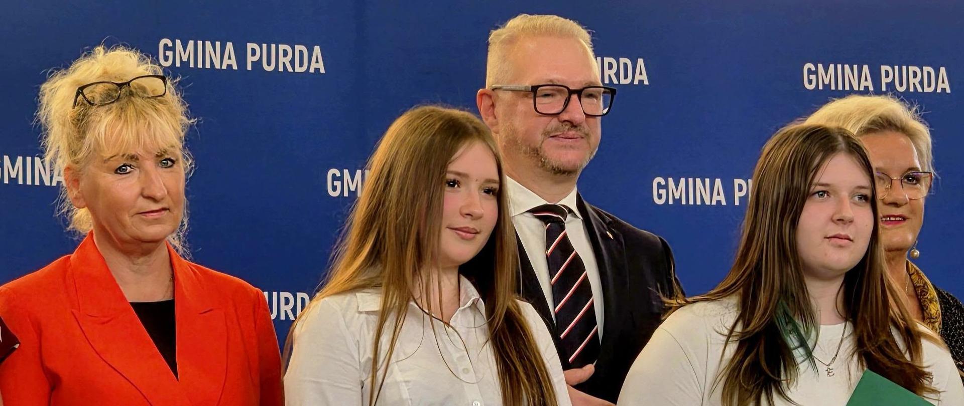 Kilka osób stoi i pozuje do zdjęcia 
