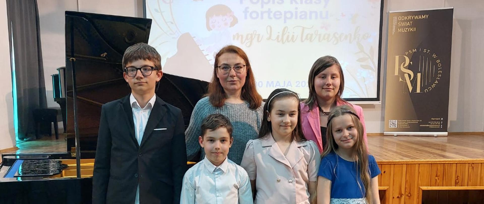 Zdjęcie przedstawiające wykonawców popisu klasy fortepianu pani Lilii Tarasenko, który odbył się 30 maja 2025 r. w auli szkoły.
