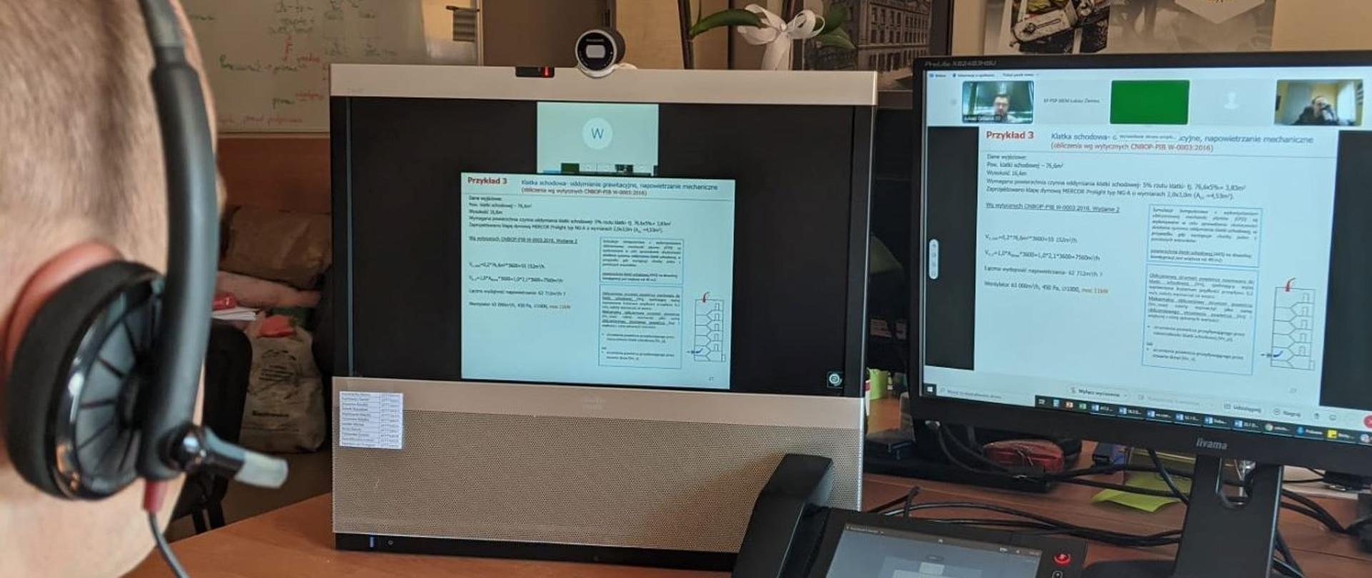 widok dwóch monitorów komputerowych oraz strażaka w słuchawkach