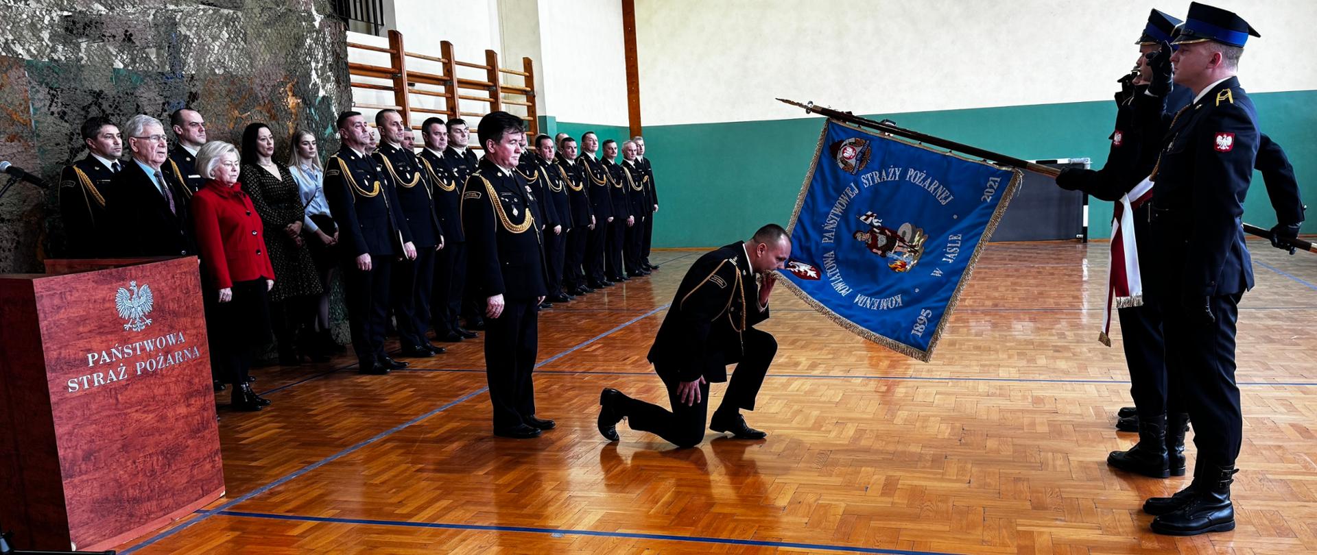 komendant całuje sztandar 