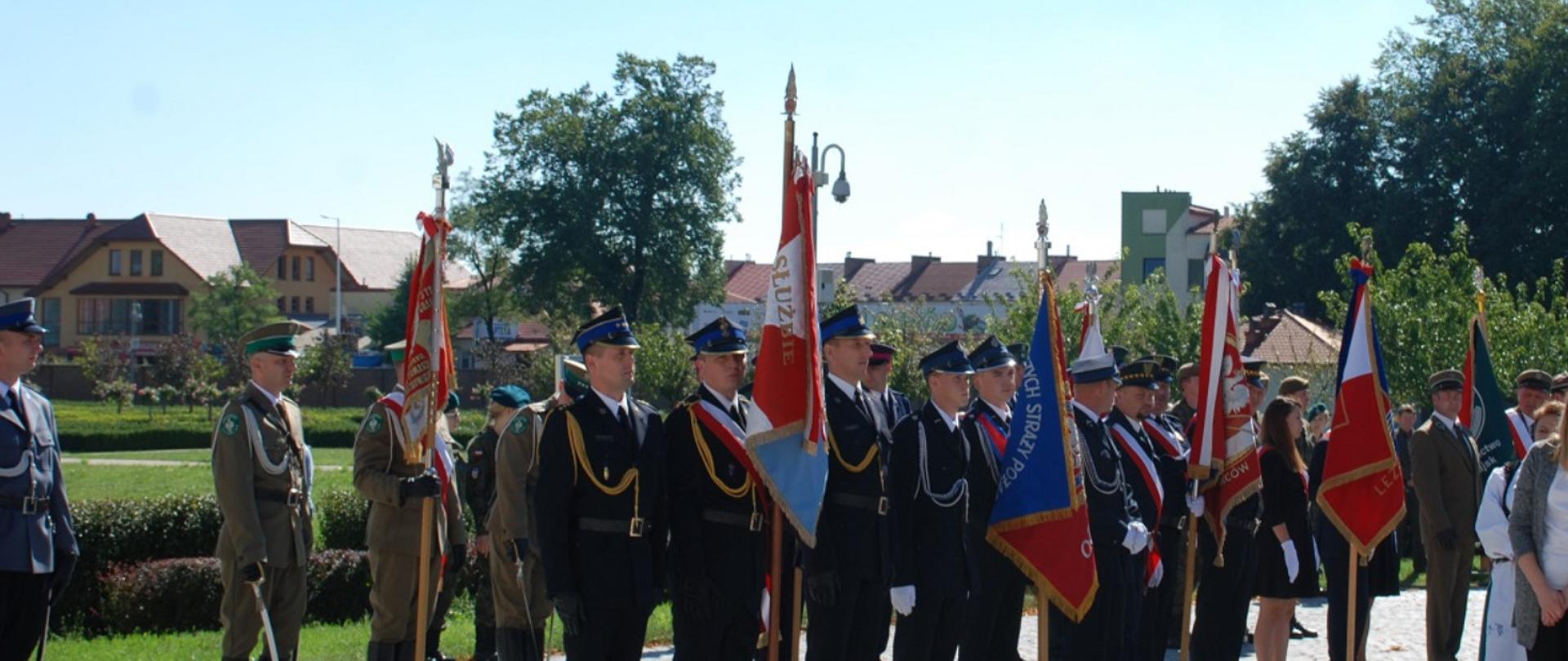 Na zdjęciu znajdują się sztandary straży oraz innych służb mundurowych z asystą funkcjonariuszy w mundurach galowych stojący na baczność.
