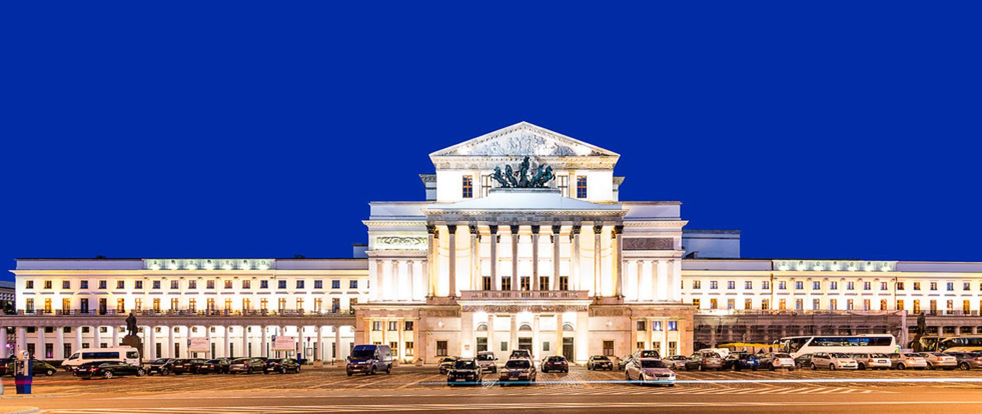 Rozświetlony budynek Teatru Wielkiego, w tle błękitne niebo