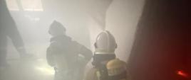Strażacy podczas przeszukania strefy zadymienia.