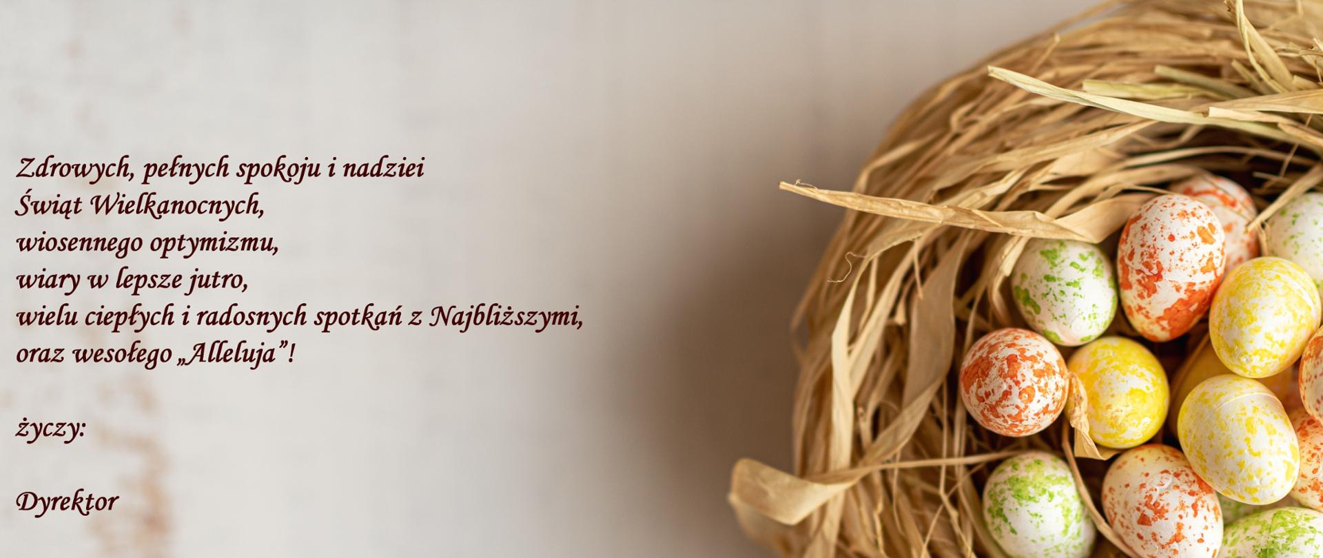 Na jasnym tle w lewej części treść życzeń wielkanocnych. Po prawej fragment koszyka wiklinowego z pisankami.