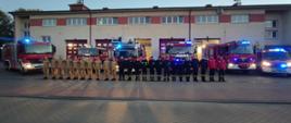 zbiórka strażaków w szeregu przed budynkiem JRG2 w Bydgoszczy, za strażakami stoi 6 samochodów pożarniczych
