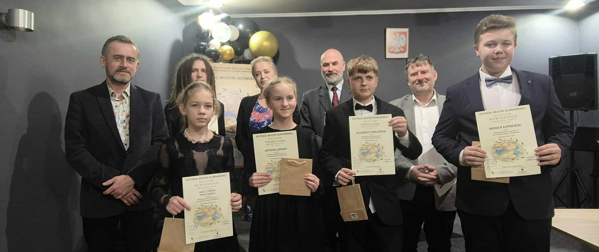 Do zdjęcia pozują z dyplomami uczniowie biorący udział w konkursie wraz z nauczycielami oraz jurorami.
