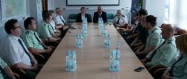 Na pierwszym planie, po obu stronach stołu, siedzą śląscy inspektorzy WITD i GITD. W tle siedzi p.o. z-ca Głównego Inspektora Transportu Drogowego Joanna Smolińska i Główny Inspektor Transportu Drogowego Alvin Gajadhur.