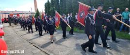 Strażacy i poczty sztandarowe maszerują na miejsce zbiórki.