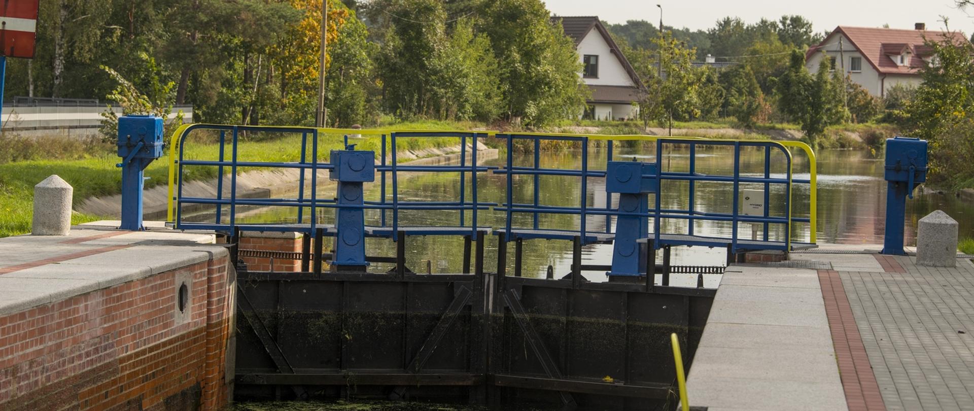 Widok na Śluzę Nr 7 - Łochowo - na Górnonoteckim odcinku drogi wodnej Warta – Kanał Bydgoski. Jednokomorowa o wymiarach komór 42,0x5,00 m wykonanych z betonu, cegły klinkierowej i ciosów kamiennych. Na głównym planie zamknięte wrota śluzy.
