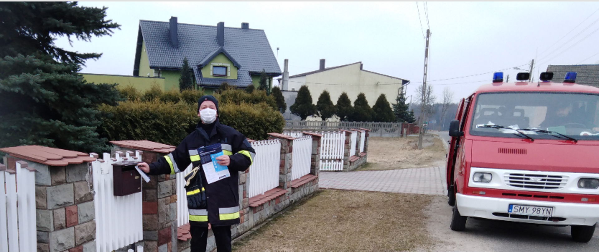 Zdjęcie przedstawia druhów OSP roznoszący ulotki z informacjami dot. szczepień przeciw Covid-19
