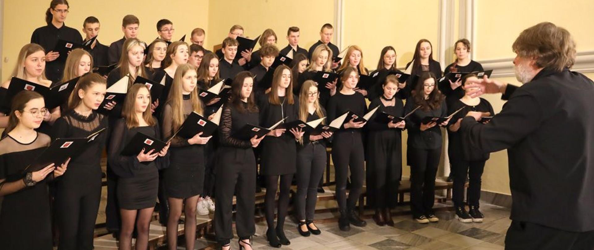Zdjęcie. Sala Muzeum Powiatowego w Nysie. Występuje Chór Mieszany PSM w Nysie, dyryguje Stanisław Kosz.