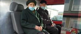 We wnętrzu samochodu lekkiego technicznego OSP Rogów siedzą dwie starsze osoby wyznaczone do szczepienia.