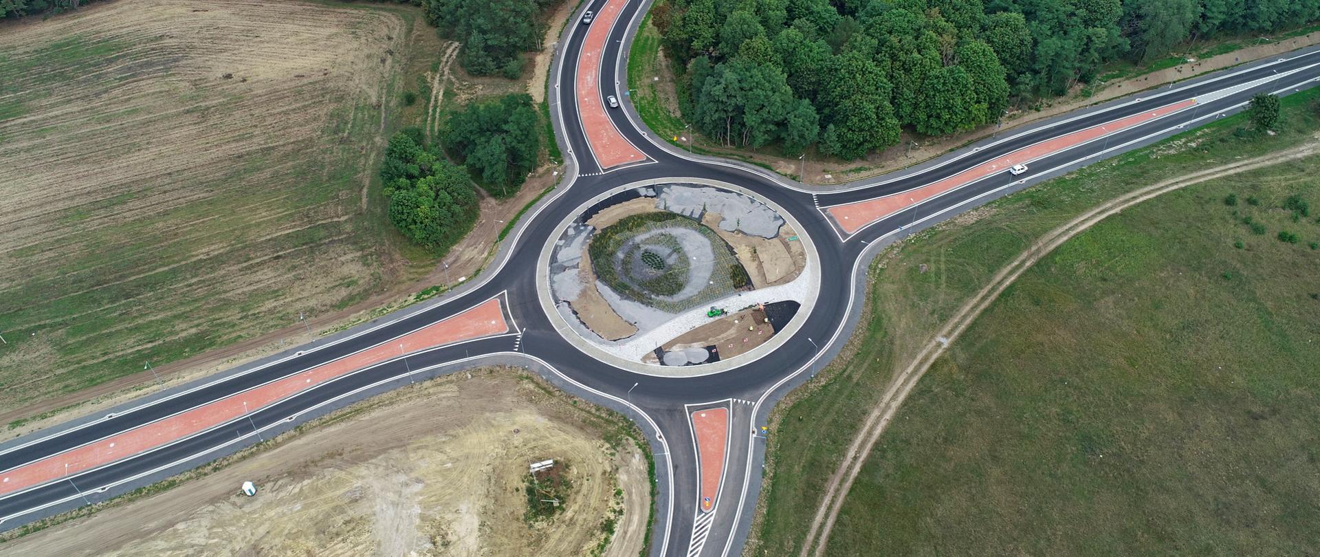 Rondo czterowlotowe z wyspami kanalizującymi, ujęcie z lotu ptaka. Dookoła zieleń.