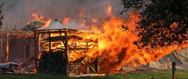 Na zdjęciu jest przedstawiony pożar zabudowań gospodarczych, budynki całkowicie objęte pożarem