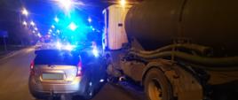 Widać samochód osobowy, który uderzył w lewy przedni bok pojazdu cieżarowego, jest noc