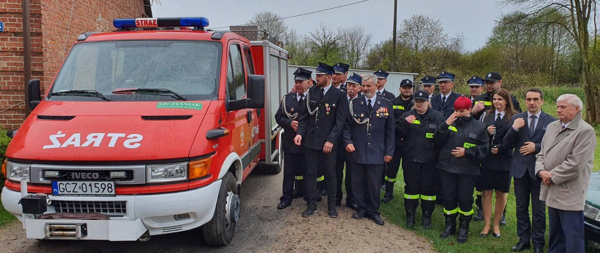 Zdjęcie przedstawia druhny i druhów z Ochotniczej Straży Pożarnej w Człuchowie oraz Wójta Gminy Rzeczenica stojących przy lekkim samochodzie ratowniczo- gaśniczym.