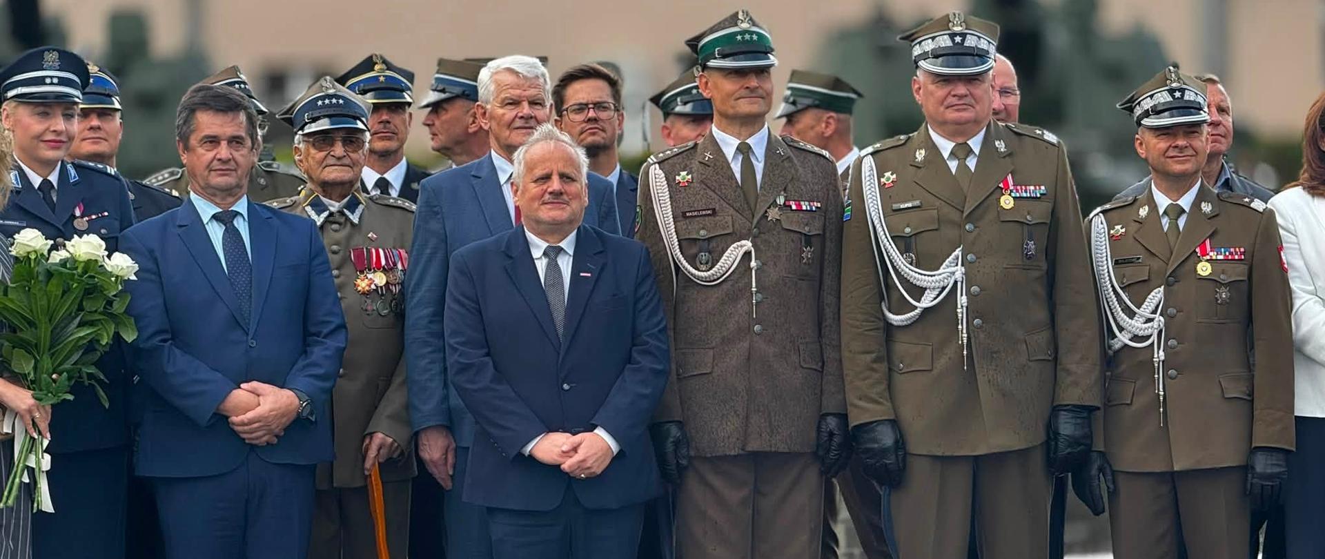 Kilkanaście osób stoi w szeregu 