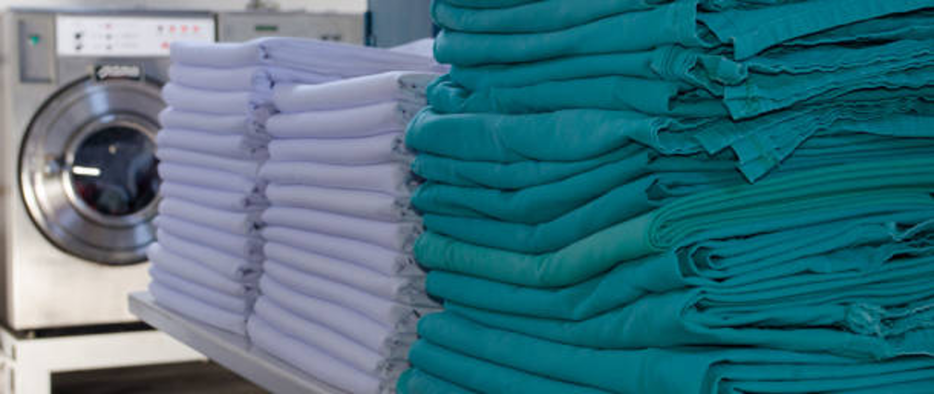 pralka, widoczne ręczniki i niebieskie przykrycia