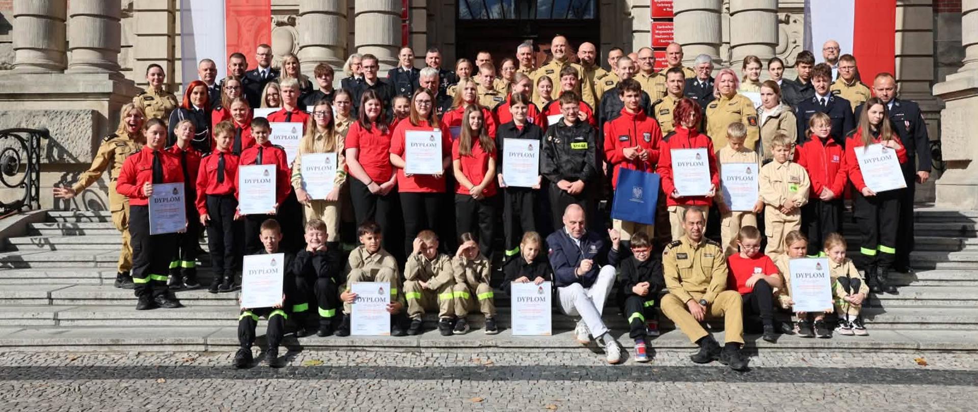 Zdjęcie grupowe na schodach przed budynkiem.
