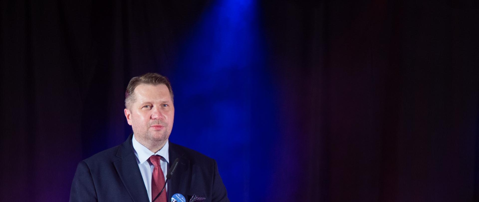 Minister Przemysław Czarnek gościem gali finałowej konkursu „Nauka dla Ciebie”, minister Przemysław Czarnek przemawia do uczestników gali, stoi przy mównicy.