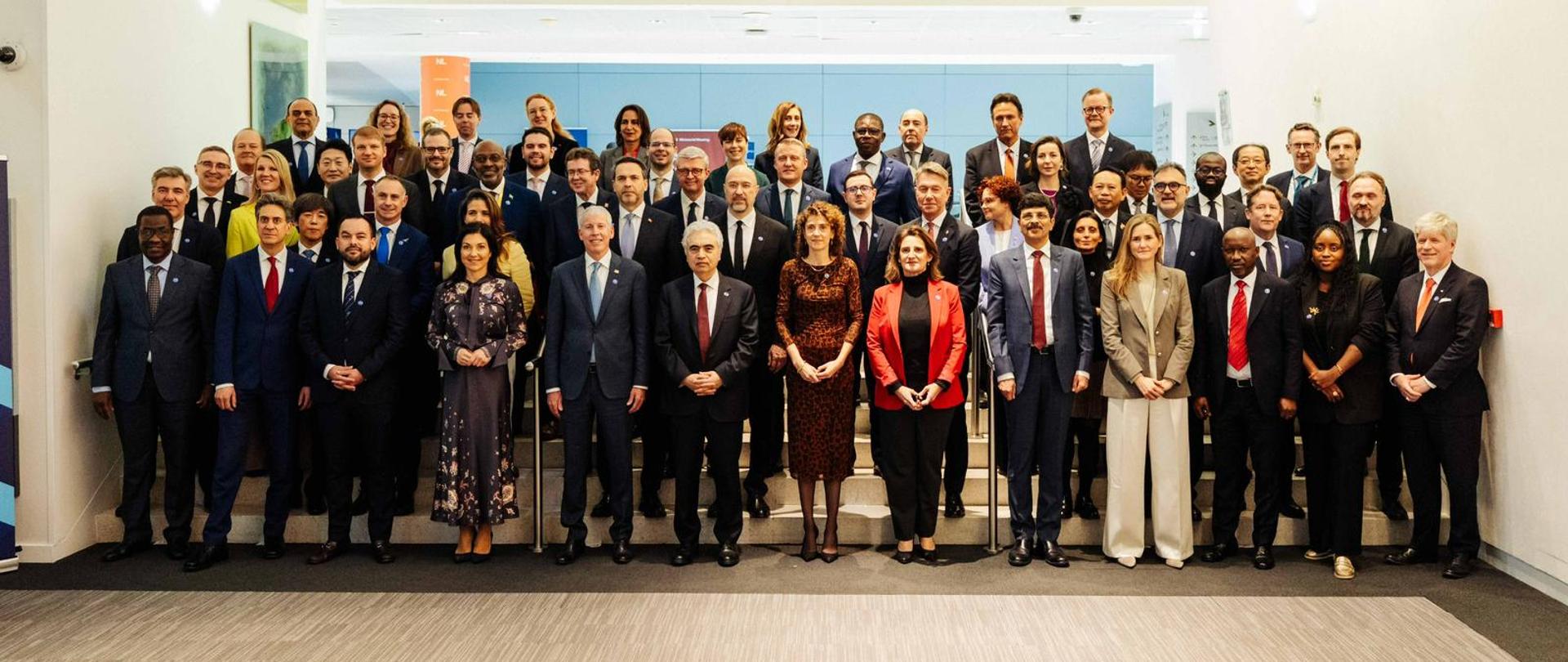 Grupowe zdjęcie uczestników Konferencji Ministerialnej IEA w Paryżu: kilkadziesiąt osób stoi w kilku rzędach, pozując do wspólnej fotografii.