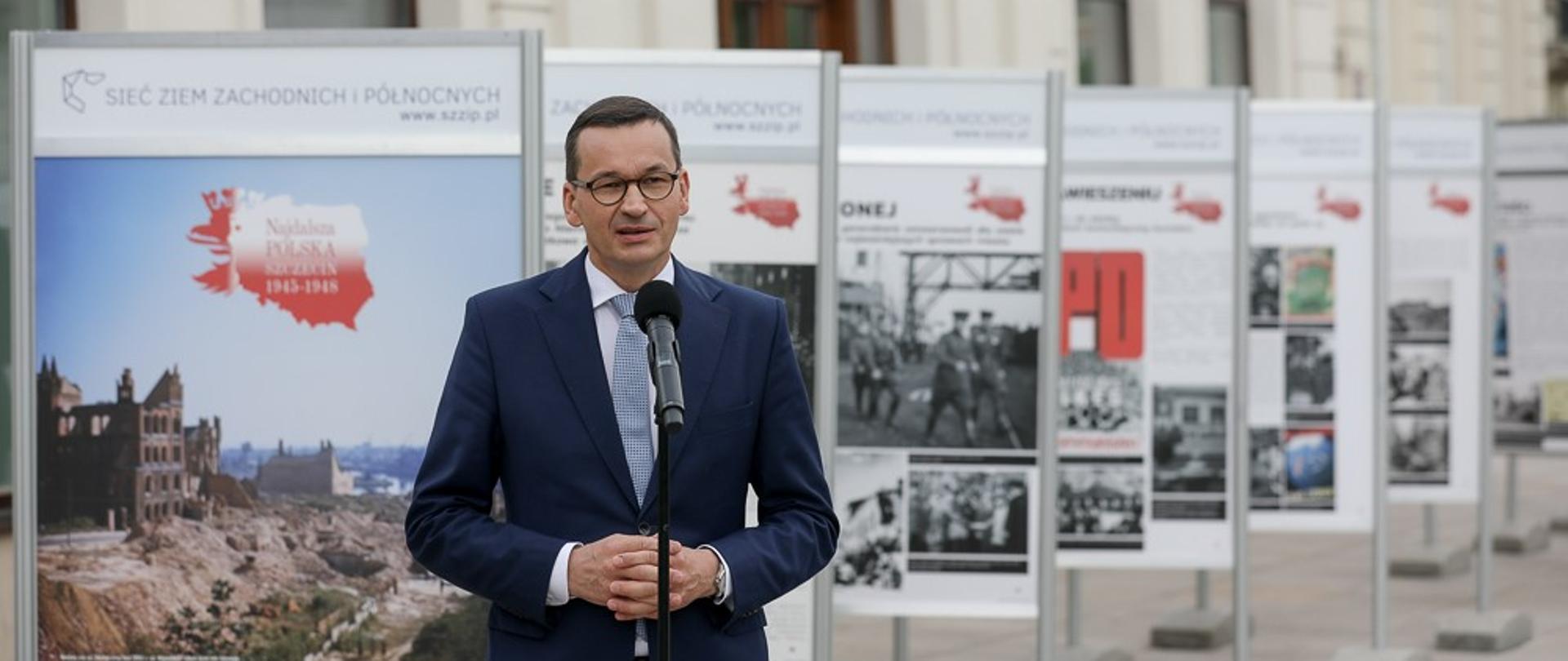 Premier na tle wystawy.