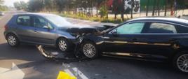 Widać dwa samochody na środku drogi, oba mają uszkodzony przód
