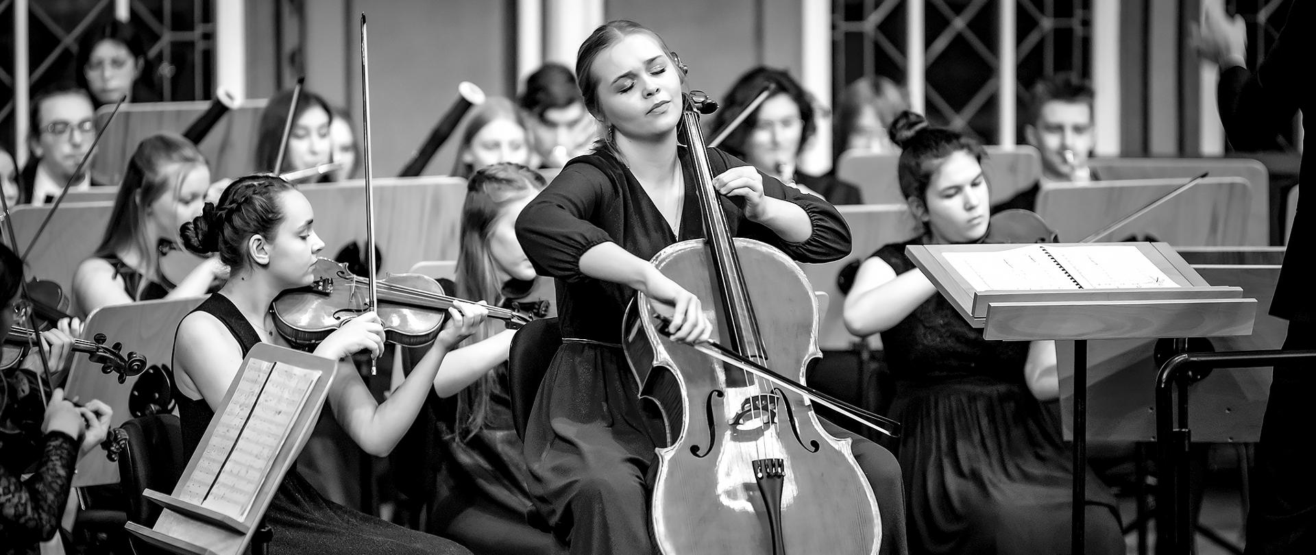 Zdjęcia - koncert dyplomantów, luty 2023 - Marcelina Morawiec, wiolonczel, na tle orkiestry szkolnej