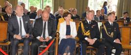 Dzień Strażaka w Rawiczu. Sala widowiskowa w domu kultury. Na krzesłach zasiadają goście zaproszeni na uroczystość. Wsród nich są m.in. przedstawiciele władz państwowych.