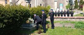 Strażacy składający kwiaty pod pomnikiem