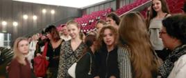 Zdjęcie grupy dziewcząt z bursy, rodziców, wychowawców i personelu na widowni w Teatrze Wielkim. Wszyscy uśmiechnięci, czekają na przedstawienie Bolero/Carmina Burana.