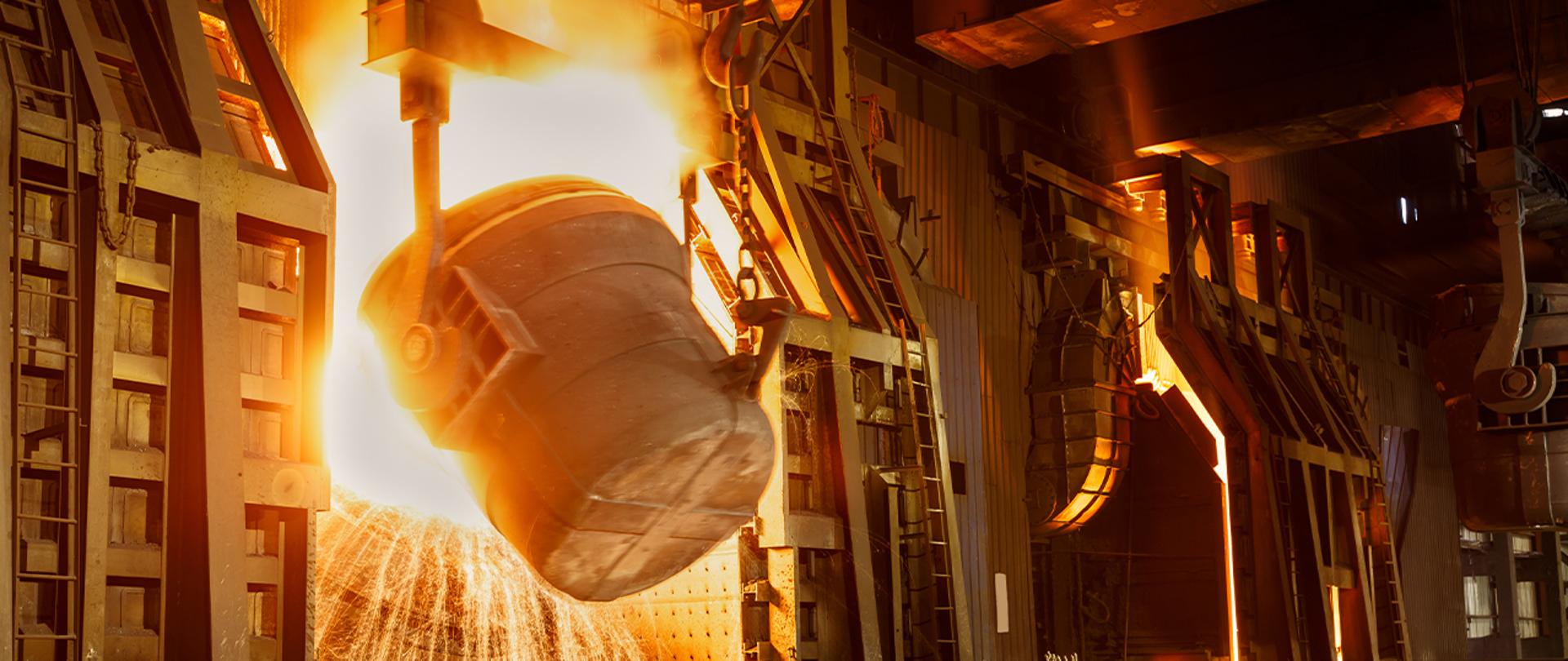 Zdjęcie przedstawia hutę. Na pierwszym planie kocioł. 