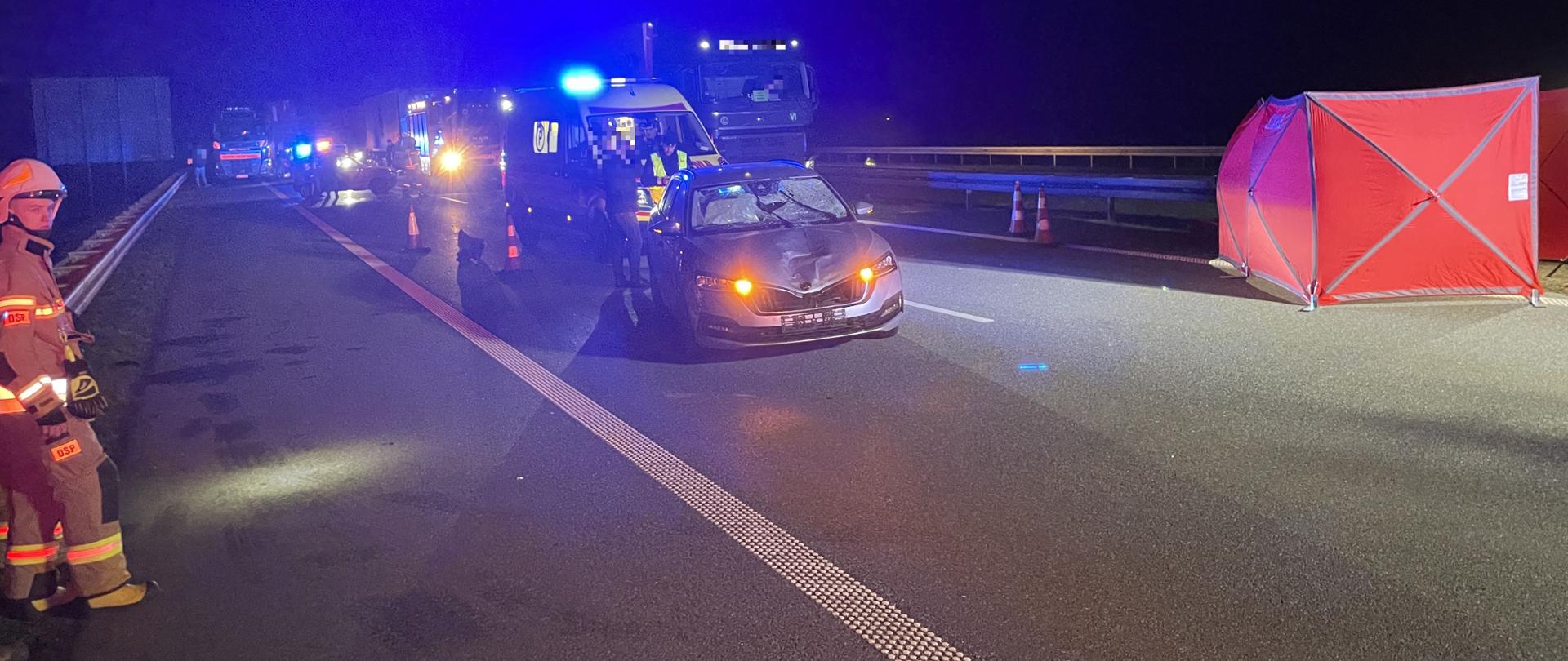 Uszkodzony samochód oraz samochody służb na autostradzie 