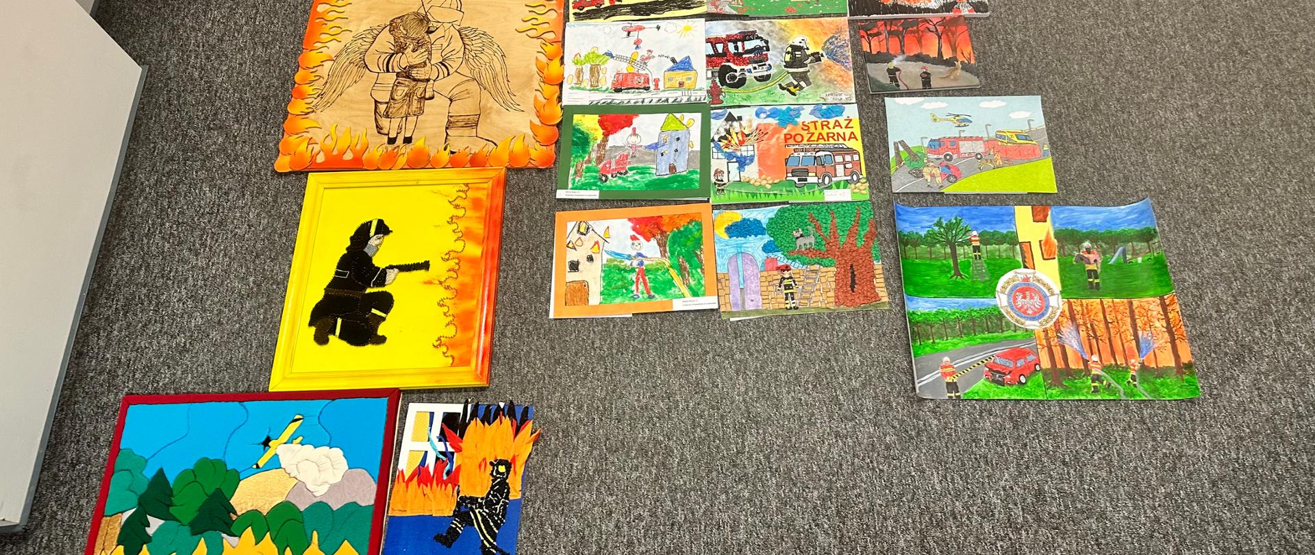 Zdjęcie przedstawia prace wykonane na konkurs leżące na podłodze